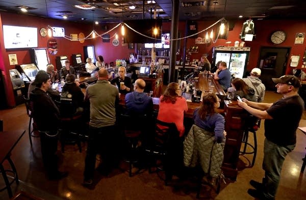 People gather at a bar. 