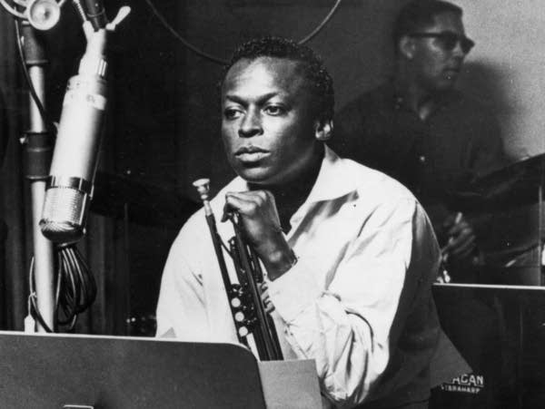 Jazz trumpeter and composer Miles Davis sits with his instrument during a studio recording session in 1959.
