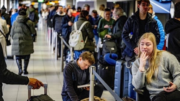 Above, travelers waiting for the KLM Airlines' service desk at Schiphol Airport on Tuesday.