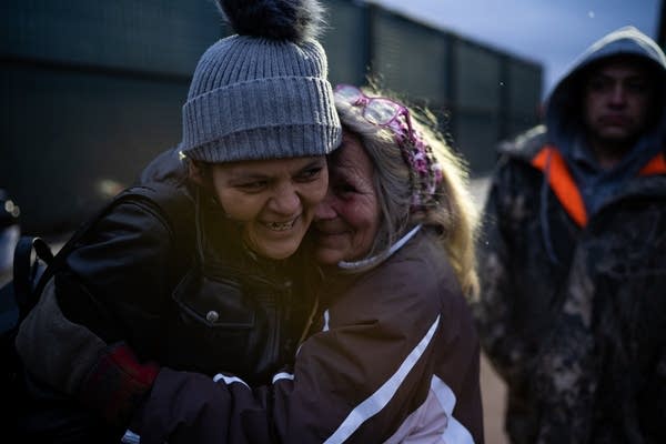 Volunteer Renee Avery hugs camp resident Kat Yanez.