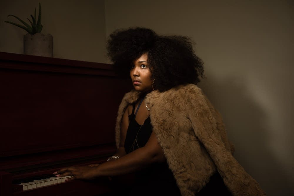 Lizzo seated at a piano