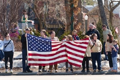 A group of people hold a U.S. flag