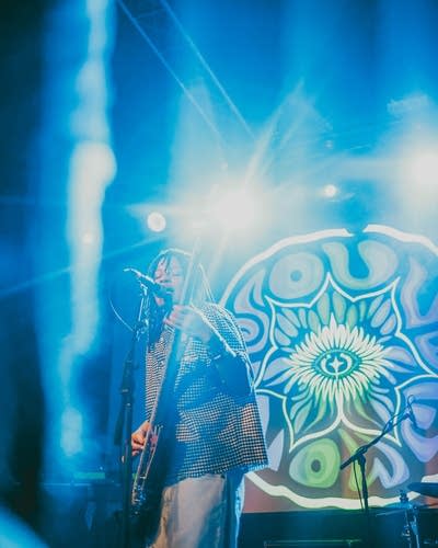 SoulFlower vocalist sings into a microphone at Fine Line.