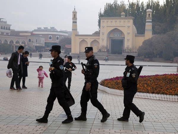 Uighur security personnel patrol near the Id Kah Mosque