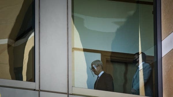 Apple CEO Tim Cook (L), followed by Apple security personnel Jimmy Taranto, makes his way to court after arriving at the United States District Court on May 21, 2021 in Oakland, California.