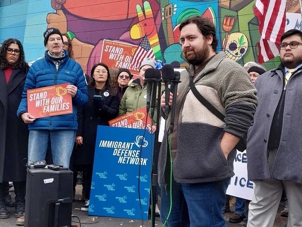 Speakers address a crowd at a community vigil