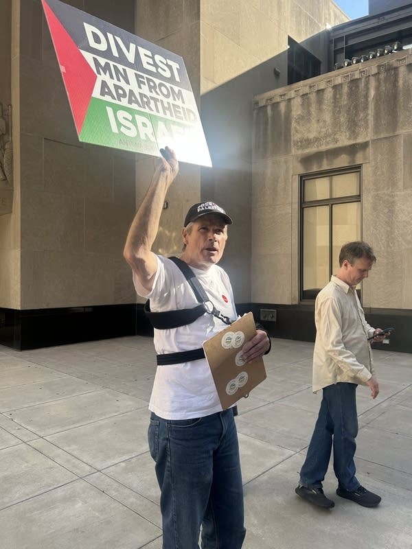 A man holds a sign