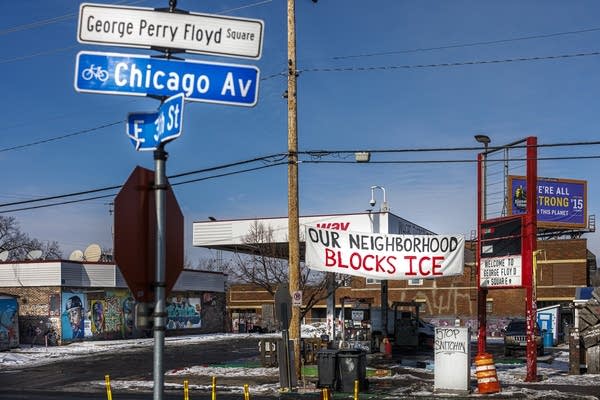 A banner reading “Our Neighborhood Blocks ICE” hangs