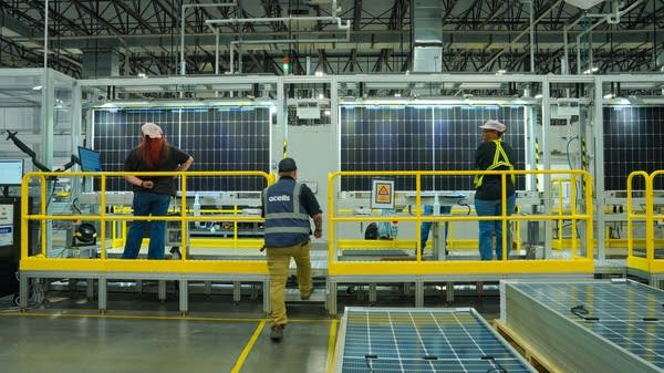 Workers at the QCells plant in Cartersville, Georgia, inspect finished solar panels before they leave the plant.