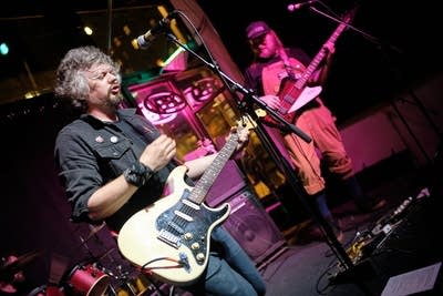 A musician sings and plays guitar onstage