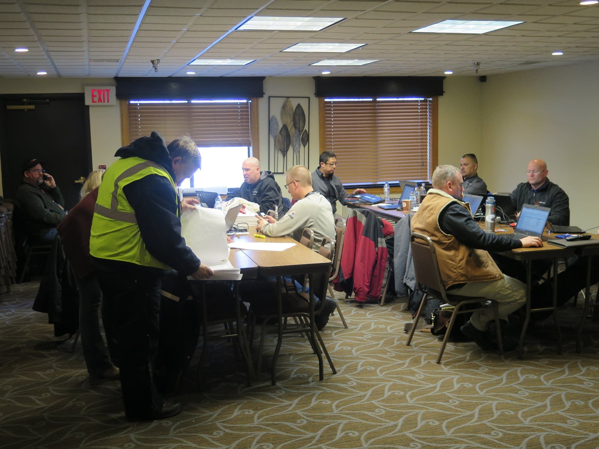 Employees work out of a conference room at the AmericInn.