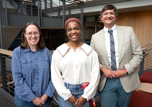 three people pose for a photo