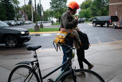 Two people hug near a bike