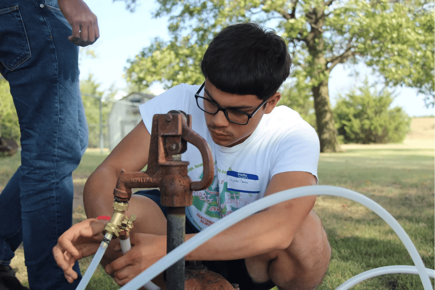 A person sampling a water well
