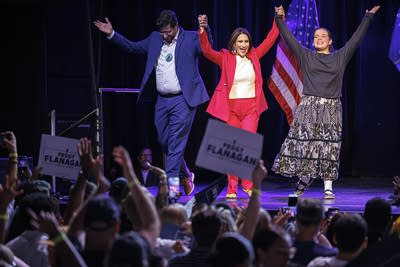 Three people raise their hands