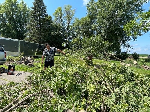 Alex Soukup throws a branch onto a large pile of brush