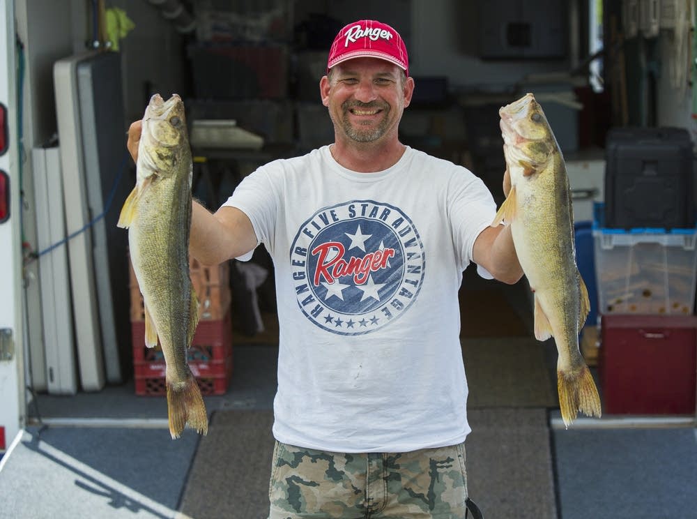 Jason Ness held up two walleye for a picture.