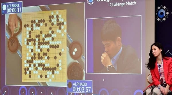 A South Korean Go game commentator (R) watches as a big screen shows the second game of the Google DeepMind Challenge Match at a hotel in Seoul on March 10, 2016.