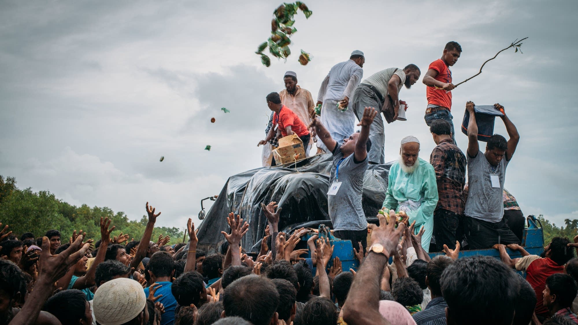 Bangladeshi volunteers distribute food to Rohingya Muslim refugees