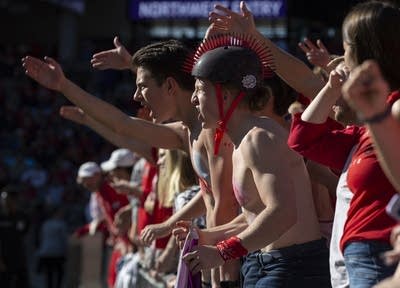 A fan wearing a helmet cheers in a crowd