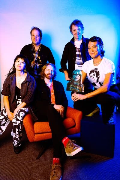 Five people pose for a studio portrait