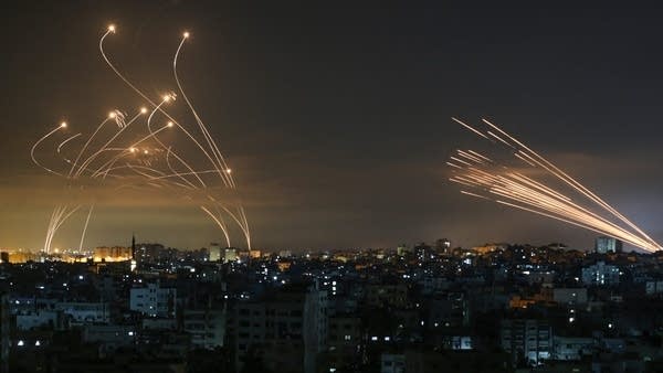Above, the Israeli Iron Dome missile defense system intercepts rockets from Hamas. 