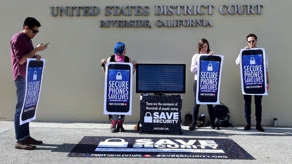 Protesters hold placards reading "Secure Phones Saves Lives" in front of the U.S. District Court in Riverside, California, where a hearing was set for legal arguments to force Apple to provide technical assistance to hack into an encrypted handset in 2016.
