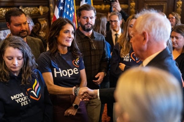 A woman shakes hands with the governor