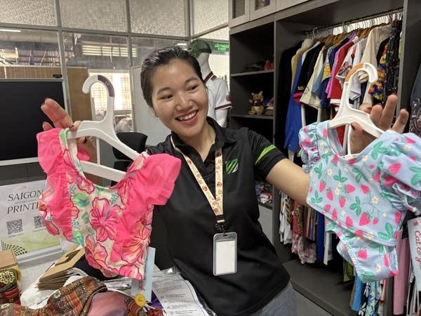 Lưu Thị Huỳnh Trang, one of Sunny Lau’s employees at Saigon Printer with two kids’ bathing suits sold at Target.