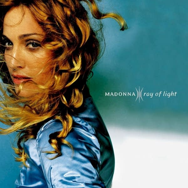 Madonna in front of a blue background.