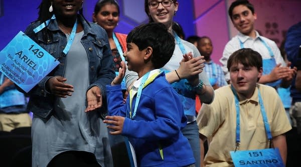 Six-year-old Akash Vukoti (center) of San Angelo, Texas bids farewell to other spellers as he leaves the stage after he misspelled his word in round three of the 2016 Scripps National Spelling Bee.