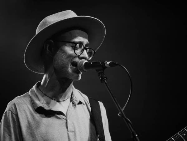 Ryan Olcott sings into a microphone