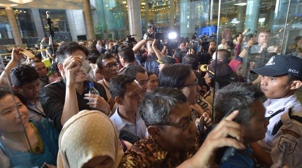 Indonesian employees return to their offices at the gedung Bursa Efek Jakarta or the Jakarta Stock Exchange building after one part of it collapsed in Jakarta on January 15, 2018.
