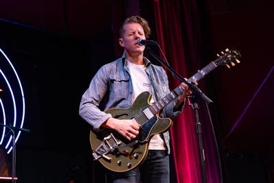 Man playing electric guitar and singing on stage