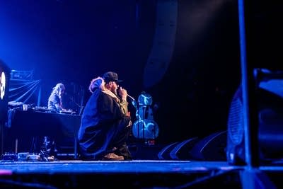 A rapper performs onstage during a show in a music venue