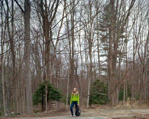 Carly stands in the woods near her home.