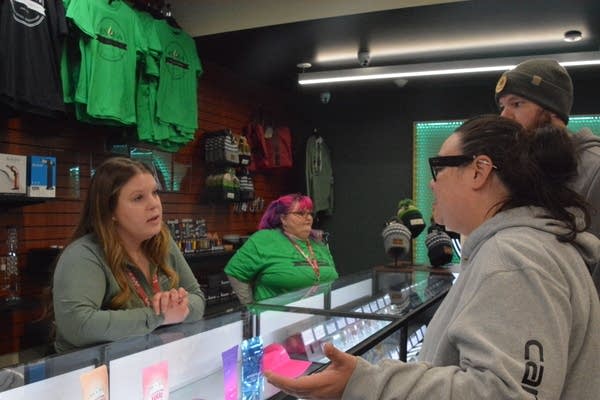 woman speaks to dispensary staff