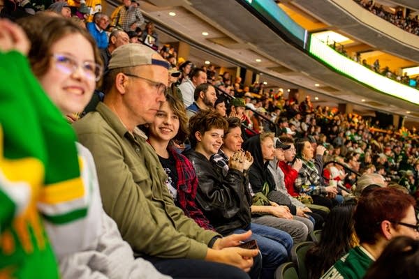 A group of people watch a hockey game