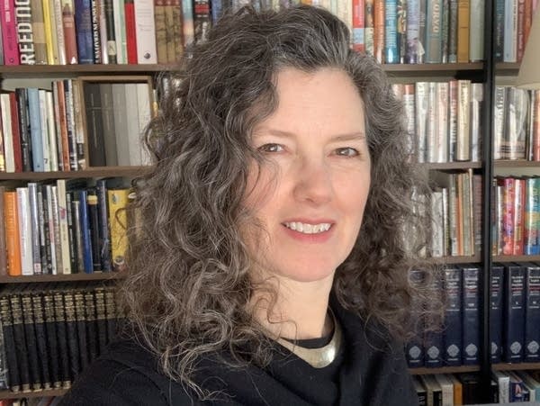 A woman's selfie in front of a bookshelf.