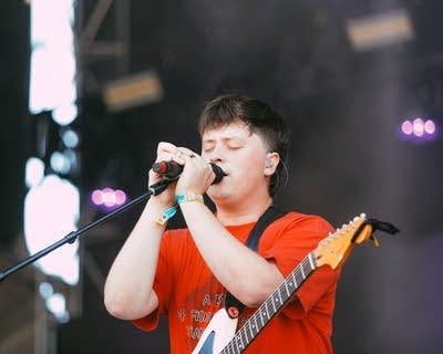 A musician sings on a large outdoor stage