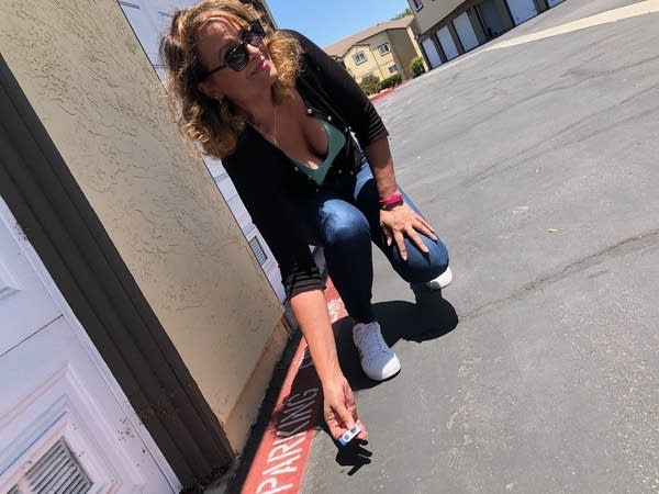 Listener Lisa bending over to pick up USB drive in parking lot