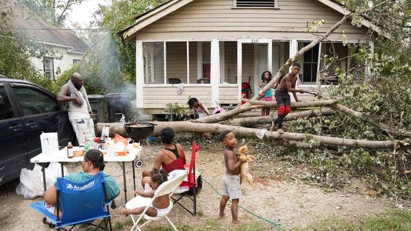A family without power prepares for dinner in their front yard after Hurricane Ida hit Louisiana in 2021.