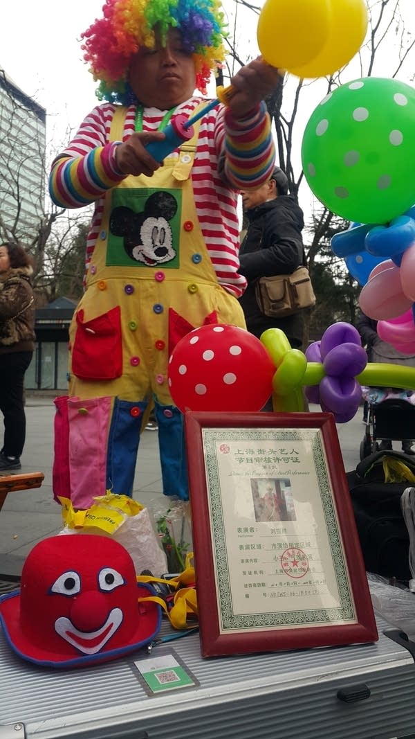 A clown in Shanghai's Jingan district also accepts mobile payment. Few people carry cash in Shanghai. (Jennifer Pak/Marketplace)