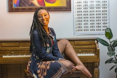A woman sits at a piano bench