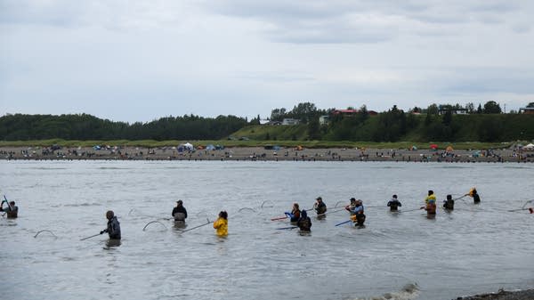 People wade in a river.