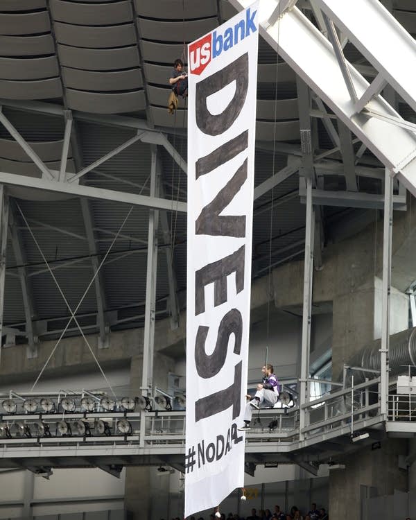 Protesters unfurl banner at Vikings game.