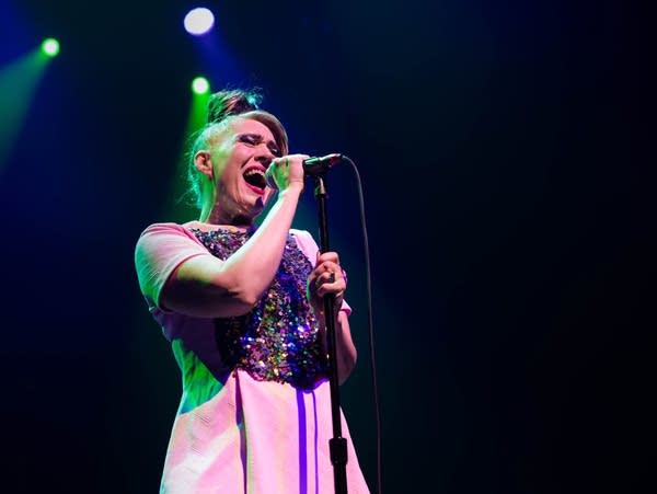 A woman sings into a microphone