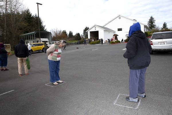 People wait six-feet apart at a food bank in Edgewood, Washington. 