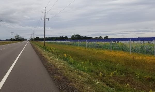 A rendering of solar panels in a field made from a photograph.