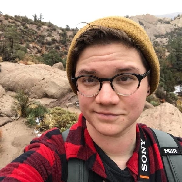 Person poses against rocky backdrop